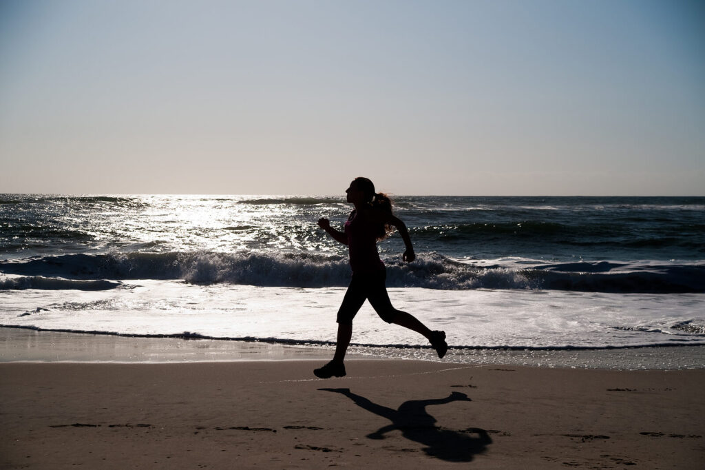 Image of a woman running on the beach. When facing the major life change of menopause, you can begin overcoming your struggle with the help of life changes therapy in Hermosa Beach, CA.