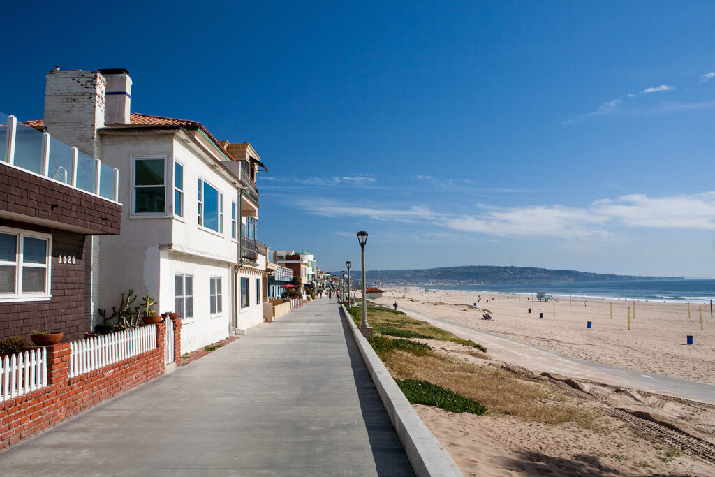 Image of a walkway beside a beach on a sunny day. Learn to integrate holistic approaches into your life with the help of a skilled life transition therapist in Manhattan Beach, CA.