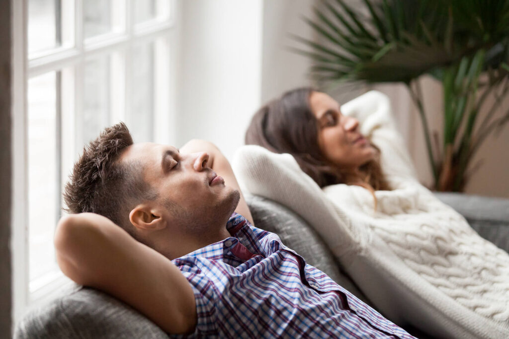 Image of a couple leaning back on a couch relaxing. If you find yourself stressed due to major life changes and are unable to cope work with a skilled life transition therapist in Manhattan Beach, CA for support.