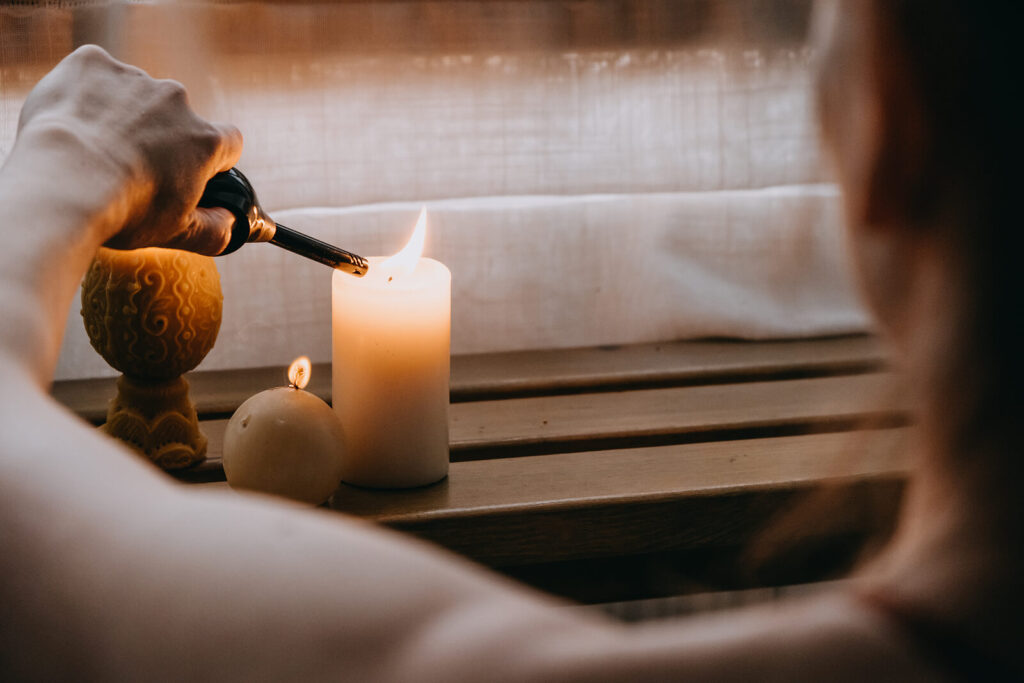 Image of a woman lighting a candle. Cultivate self-compassion and navigate your anxiety symptoms with the help of anxiety therapy in Manhattan Beach, CA.