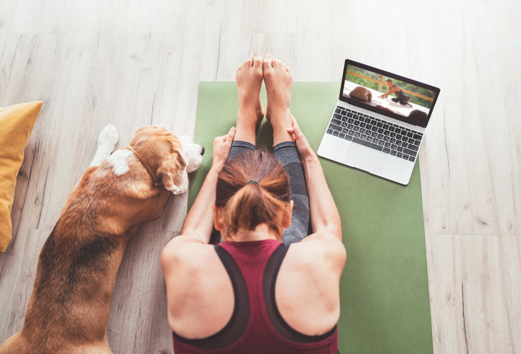 Image of a woman sitting on the floor in a yoga pose with her dog beside her. With holistic anxiety therapy in Manhattan Beach, CA you can find natural ways to heal your symptoms. 